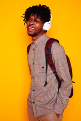 young handsome african american guy student posing cheerful and gesturing on yellow background, lifestyle people concept