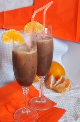 Sweet coctails in high glasses decorated with fruits on table