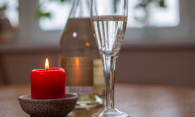 Wine sparkling white, glass and a candle on the table