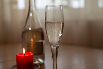Wine sparkling white, glass and a candle on the table
