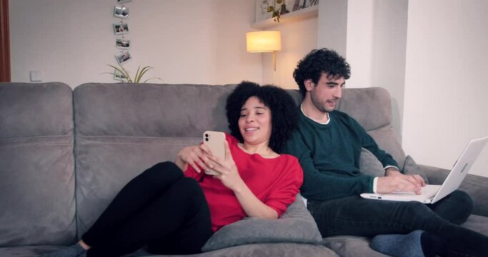 Couple at home working and entertaining with cell phone