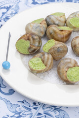 escargots au beurre persillé dans une assiette