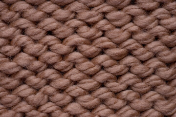 Macro shot of brown woolen knitted fabric texture.