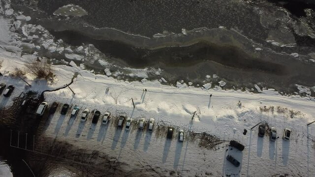 Small people on the background of a frozen huge river