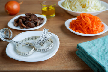Healthy eating. Vegan food. Mushrooms, raw, chopped vegetables for salad on white plates. Cabbage, carrots, onions. Olive oil.