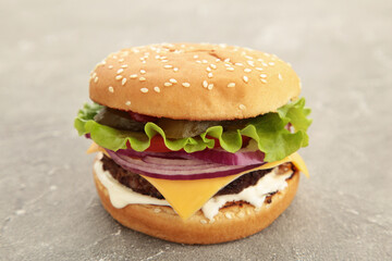 Fresh tasty burger on a grey table.