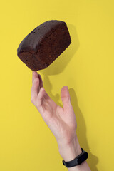 Loaf of rye bread, balanced on a hand with fitness band. Concept of sustainable consumption and healthy nutririon.