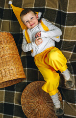 Boy 4 years old on home plaid in yellow gnome elf outfit with basket