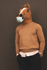 man with horse mask protecting himself with a mask from viruses