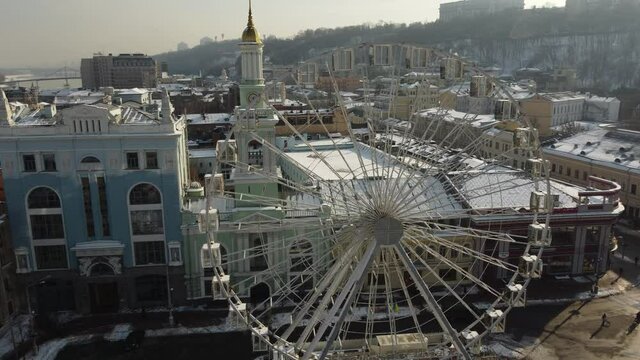 huge ferris wheel against the background of the church and the city in the sun