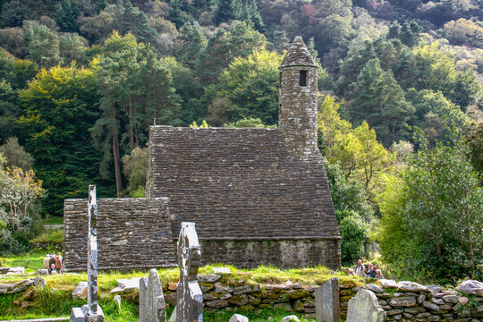 Glendalough Monastic ruins Co. Wicklow, Ireland. View of St. Kevin's Church, tombstones and Celtic cross in adjoining cemetery.  
