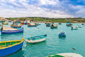 Fototapeta na wymiar Typical fishing boats at the village of Marsaxlokk on the island of Malta