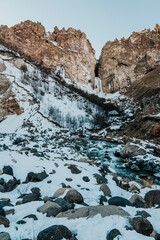 Fototapeta na wymiar Photo of a frozen waterfall in the winter in the mountains. Travel across Russia to the Caucasus Mountains. 