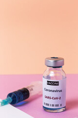 Transparent glass vials with test COVID-19 vaccine, with syringes