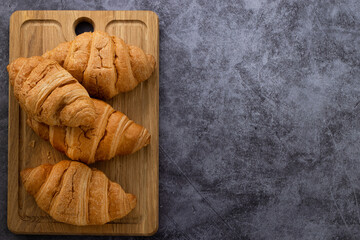 fresh croissants and coffee on stone background with copy space. Top view