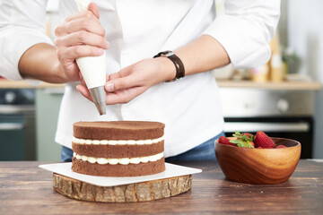 Pastry bakery chef in the kitchen decorating cake bakery and food concept.