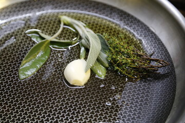 Salbei, Rosmarin, Knoblauch in der Pfanne