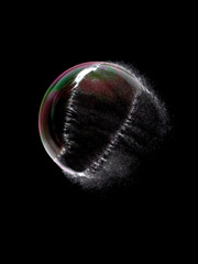 Popping Soap Bubble Exploding on Black Background