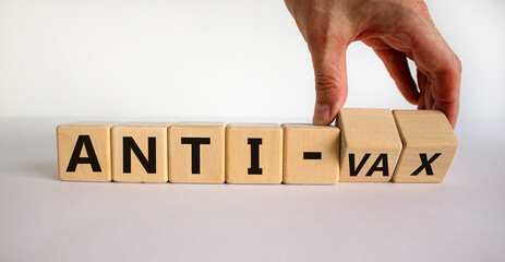 Anti-vax symbol. Doctor turns cubes with words 'anti-vax'. Beautiful white background. Copy space. Business, medical covid-19 vaccination or anti-vax concept.