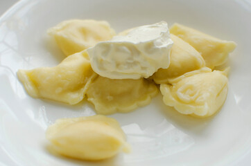 Dumplings with cottage cheese and sour cream, close-up.