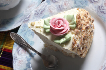 Close-up piece of sweet meringue cake with cream rose