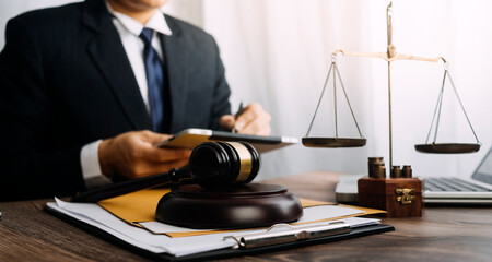 Business and lawyers discussing contract papers with brass scale on desk in office. Law, legal services, advice, justice and law concept picture with film grain effect