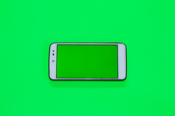 Smartphone with green screen on green background.