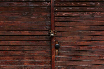Dark brown wooden door with metal handle garage antique balkan aged with rusted metal bars in Sofia, Bulgaria, Eastern Europe