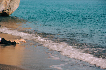 castaway: man's legs on the water's edge