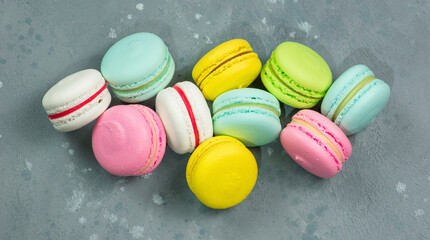 Fresh colored cookies macarons on a gray background.