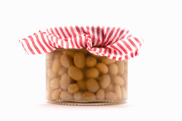 Delicious homemade canned Italian zolfini beans in a glass jar close up isolated on a white background