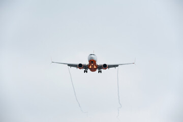 The plane with landing lights on and released chassis prepare for landing