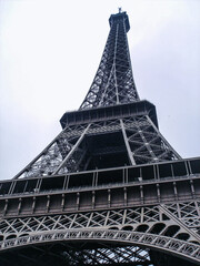 Paris.
Eiffel Tower In Paris. Looking Up At The Famous Iron Tower In Paris, Against A Gray Cloudy Sky. Travels