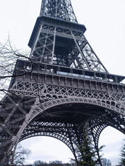 Paris.
Eiffel Tower In Paris. Looking Up At The Famous Iron Tower In Paris, Against A Gray Cloudy Sky. Travels