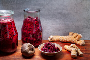 Beetroot salad with grated horseradish addition and fermented beetroot liquid. Bowls and glass jars.