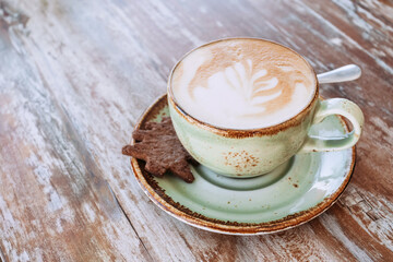 Coffee in blue cup on wooden table in cafe with lighting background.