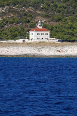 Fototapeta na wymiar Picturesque lighthouse on small island near Hvar, Croatia.