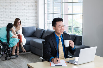 Businessman sitting on workplace drinking coffee while working at his desk. Handsome businessman working on laptop in his workstation in office. Mature businessman working on laptop computer.