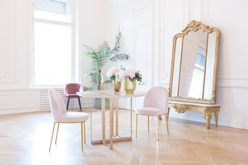 chic spacious light room in an old mansion in the classical style of the 19th century with a high ceiling decorated with stucco on white walls