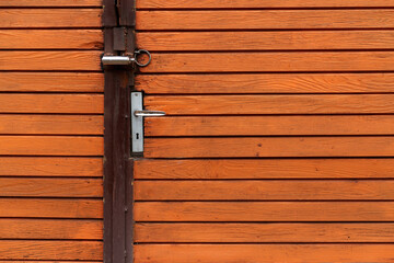 Orange painted wooden door with metal handle garage antique balkan aged with rusted metal bars in Sofia, Bulgaria, Eastern Europe