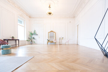 chic spacious light room in an old mansion in the classical style of the 19th century with a high ceiling decorated with stucco on white walls