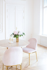 chic spacious light room in an old mansion in the classical style of the 19th century with a high ceiling decorated with stucco on white walls