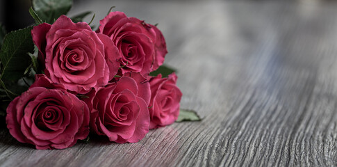 bouquet of pink roses on wooden table surface