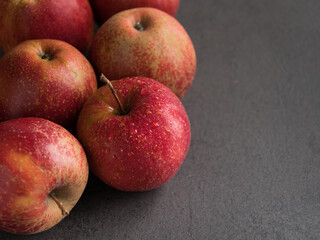 Three red juicy apples on stone table