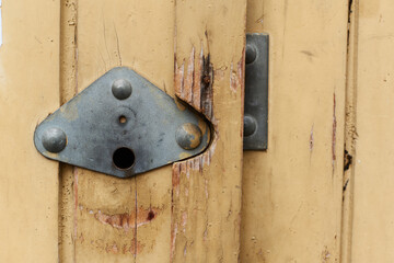 Closeup of yellow old wooden door with metal handle garage antique balkan aged with rusted metal bars in Sofia, Bulgaria, Eastern Europe