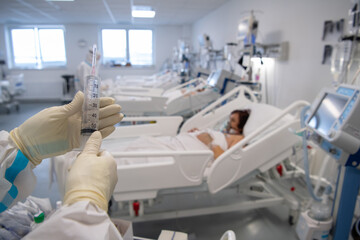 Nurse is preparing intravenous medication in intensive care unit.