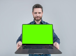 Bearded computer guy hold open laptop with neon green screen for copy space, notebook