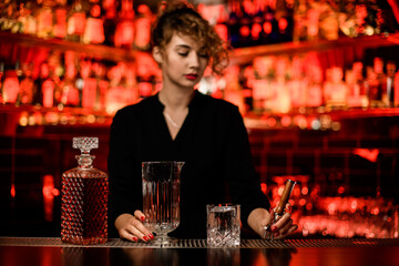 beautiful view of crystal decanter with liqueur and mixing cup and glass on bar counter