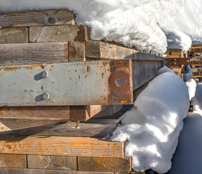 Dimensional Lumber And Rusty Steel Plates Piled Under Deep Snow Closeup Nobody