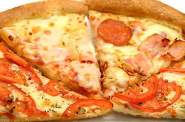 Big appetizing Italian pizza pieces on white plate front view close up